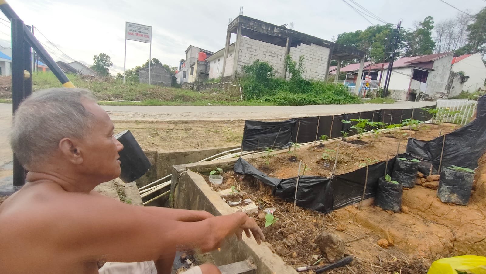 Soegianto atau yang biasa disapa Kakung bertelanjang dada pada Sabtu 14 Juni 2025 pagi di kawasan ruang terbuka hijau Gala Puncak RT25, Pesona Bukit Batuah, Kelurahan Graha Indah, Kecamatan Balikpapan Utara, Kota Balikpapan, Kalimantan Timur. Melakukan bersih-bersih sampah dan berkebun menghijaukan alam. (Foto : Budi Susilo)