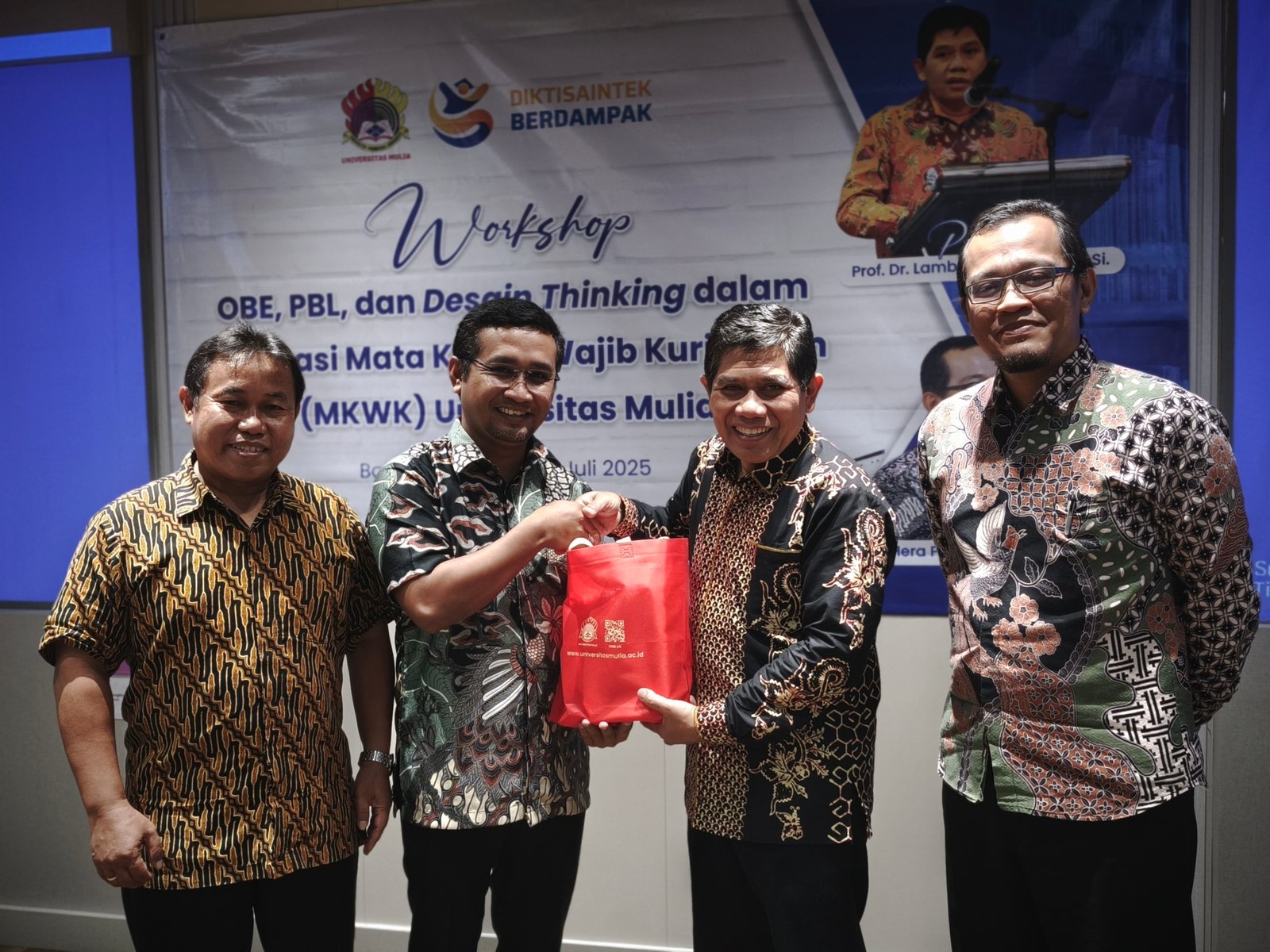 Ketua Panitia Workshop, Yeyen Dwi Atma, S.Kom., M.Kom., menyerahkan cinderamata kepada narasumber Prof. Dr. Lambang Subagiyo, disaksikan oleh Wakil Rektor Bidang Akademik dan Sistem Informasi, Wisnu Hera Pamungkas, S.T.P., M.Eng., serta Wakil Rektor Bidang Sumber Daya, Yusuf Wibisono, S.E., M.T.I. (Humas Universitas Mulia)