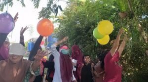 Emak-emak lomba HUT RI di Gala Puncak RT 25, Perumahan Pesona Bukit Batuah, Kelurahan Graha Indah, Balikpapan Utara, Kota Balikpapan, Provinsi Kalimantan Timur. Balon-balon warna-warni tergantung di antara pohon cery dan pagar besi hijau. Dengan mata tertutup kain merah putih, para peserta maju satu per satu, menebak-nebak arah sambil membawa sebatang tusuk bambu. (HO/Gala Puncak)
