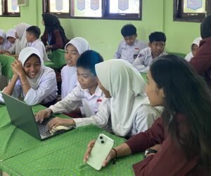 Para mahasiswi KKN antusias membimbing siswa SDN 003 Balikpapan Selatan dalam praktik desain grafis menggunakan Canva. (foto : Humas : Universitas Mulia)